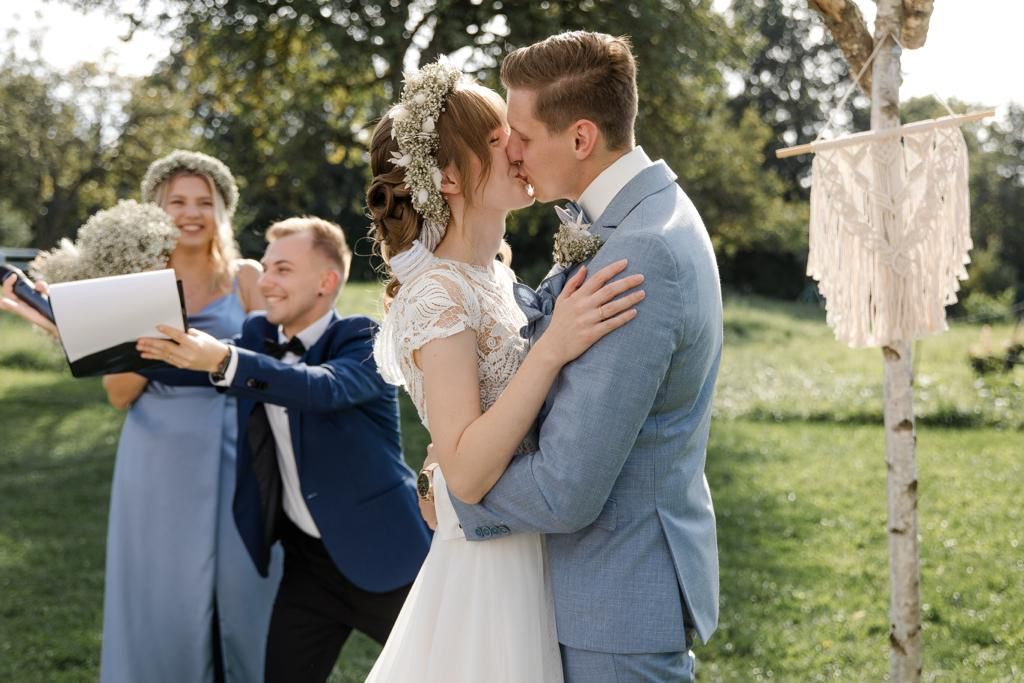 Brautpaar k&uuml;sst sich nach der freien Trauung im Gr&uuml;nen bei einer multikulturellen Hochzeit in Heilbronn